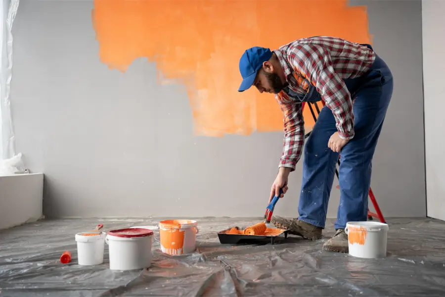 A man is painting a wall